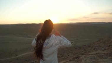 Genç kadın zafer çöl dağ tepe üzerinde duran kollarını kaldırdı