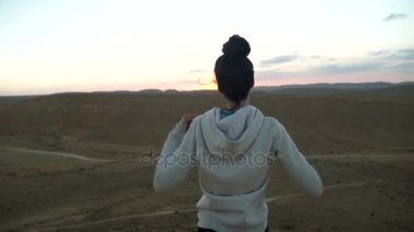 Genç kız kadar elleri havada bir çöl manzarası