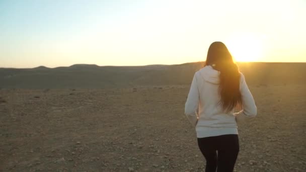 Παρακολούθηση πλάνο του μια κοπέλα περπάτημα στην έρημο — Αρχείο Βίντεο