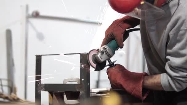Ремесленник использует шлифовальный станок на металлической конструкции — стоковое видео