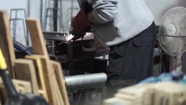 Sparks fly from metal grinder in workshop — Stock Video