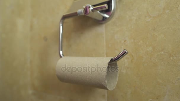 Hand touches empty roll of toilet paper — Stock Video