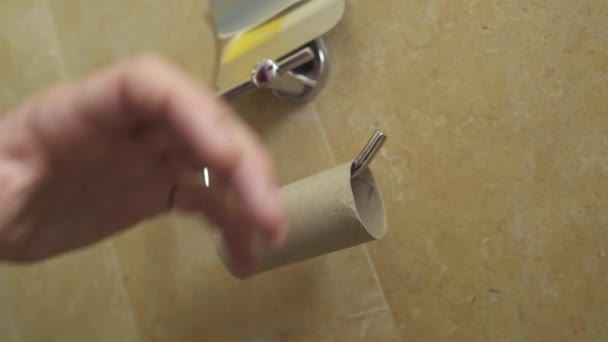 De mens is boos op een lege rol wc-papier - gooit het — Stockvideo