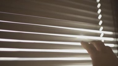 Dışarı bakmak için pencereyi çeken bir eli kapat.