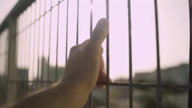 Yakın çekim - şehirde güneşli bir günde metal bir çit tutmak