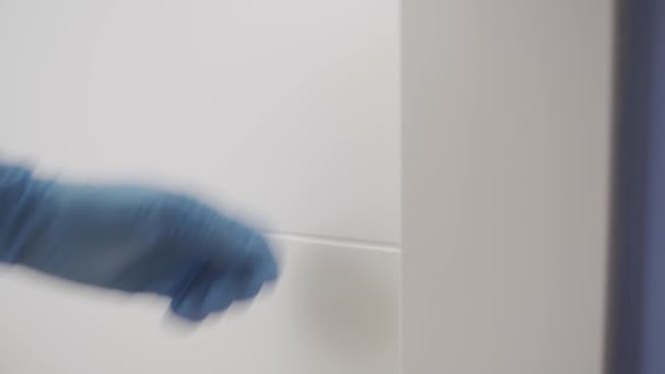閉じる 青いラテックス手袋で手でドアをノック — ストック動画