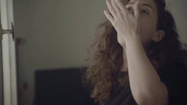 Kadın hap yutar ve cam bardaktan su içer.