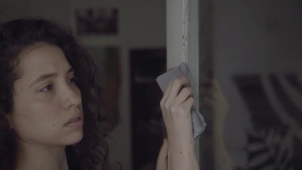 Νεαρή Γυναίκα Σκουπίζει Ένα Γυάλινο Παράθυρο Πόρτα Ένα Διαμέρισμα — Αρχείο Βίντεο