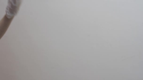 Main avec un gant en latex médical blanc fait des gestes 