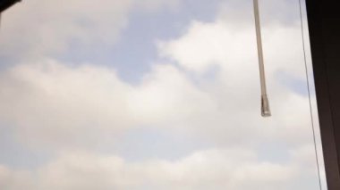 Pencerenin ortasında Venedik panjurları düşüyor.