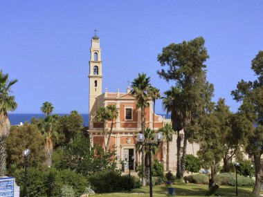 güzel tarihi St. Peters kilise içinde Jaffa, Tel Aviv bir banliyösünde görüntüleyin. Pek çok ağaçlar, palmiye ağaçları ve çiçek yeşil bir parkta yer alan