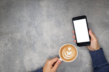 Sağ el bir telefon ve sol elinde bir fincan holding holding