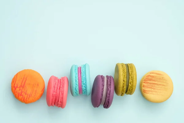 Macarrones coloridos sobre fondo turquesa . — Foto de Stock