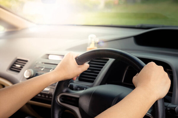 Женские руки водителя на руле
