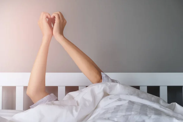 Estirando el brazo fuera de la manta — Foto de Stock