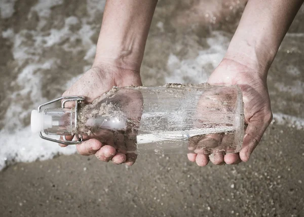 Bir mektup ile bir şişe tutan el