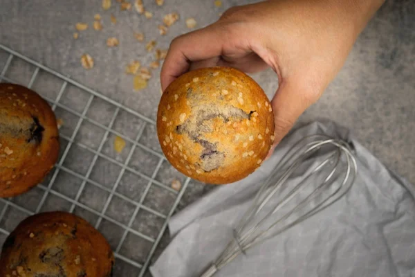 Hænderne med en muffin ser lækre ud. Vælg fokus . - Stock-foto