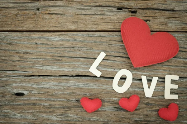 Piros párna szíve és a szeretet szó a fából készült háttér — Stock Fotó