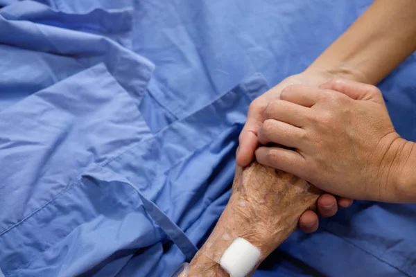 La mano de la mujer sostiene la mano de la madre Imagen De Stock