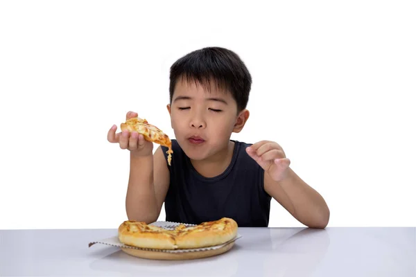 Cute boy is closing his eyes and enjoying eating pizza — Stock Photo, Image
