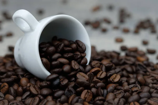 Chicchi di caffè fuoriusciti dalla tazza di ceramica bianca — Foto Stock