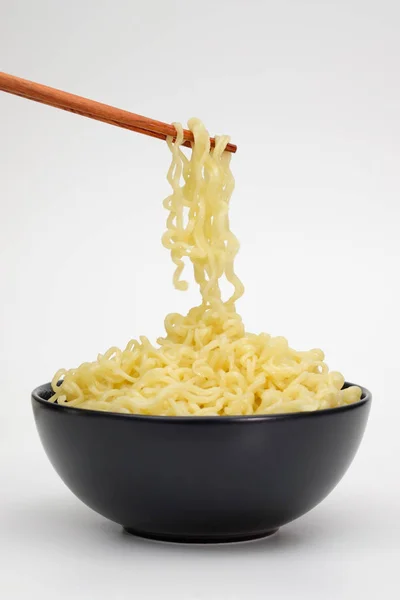 白い背景で隔離の箸を使ってインスタント麺の黒ボウル — ストック写真