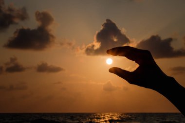 Düşen güneş yakalamak siluet eller.