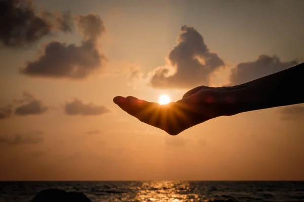 Silhouette Hände fangen die fallende Sonne. — Stockfoto