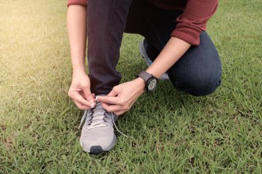 Atlet ayakkabı ipi günbatımı zamanında oturur.