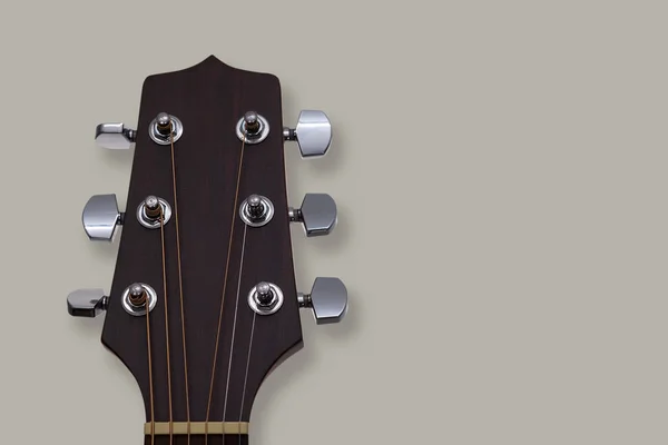 灰色の背景にアコースティック ギターのヘッド ストック. — ストック写真