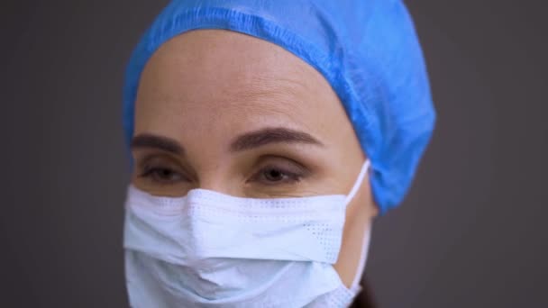保護マスクの深刻な外科医や看護師は、前方の眺めを見ています.外科用キャップとマスクを身に着けている女性医療専門家, Covid-19.伝染に対する対策。ProRes 422クリップ, 4K UHDで撮影. — ストック動画