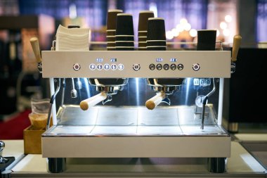 İş istasyonunda profesyonel kahve makinesi var. Espresso makinesi kullanıma hazır. Üzerinde plastik bardaklar olan kahve makinesi açıldı ve çalışmaya hazır. Mutlu olmak için kahve iç..