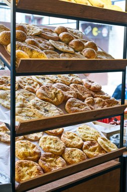 Hamurdan, peynirden ve pastırmadan yapılmış Khachapuri yassı ekmeği bir fırının ahşap raflarında. Gürcü geleneksel khachapuri sokak yemekleri festivalinde. Geleneksel Gürcü hamur işleri.