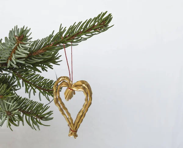 Рождественские украшения соломенное сердце на серебристой елке ветки на — стоковое фото