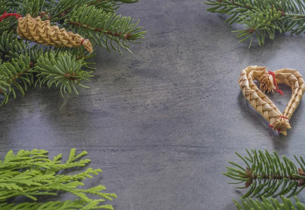 Горизонтальное рождественское украшение еловой ветви и соломенного сердца — стоковое фото
