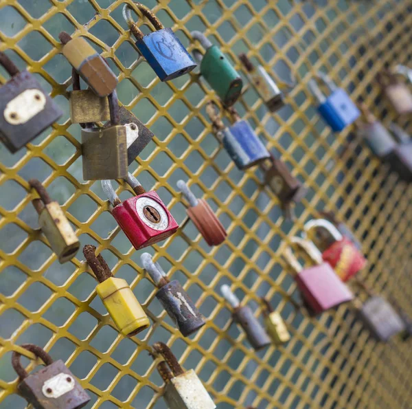 Cerraduras de colores colgando de cerca de cadena amarilla —  Fotos de Stock