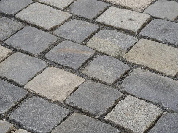 Cerca de la ciudad vieja adoquines gris pavimentación piedra cuadrada backgroun —  Fotos de Stock