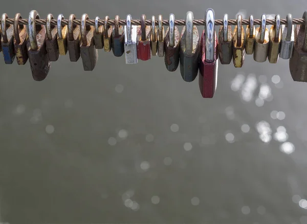 Serrures colorées suspendues à un fil haut de pont avec lumière bokeh — Photo