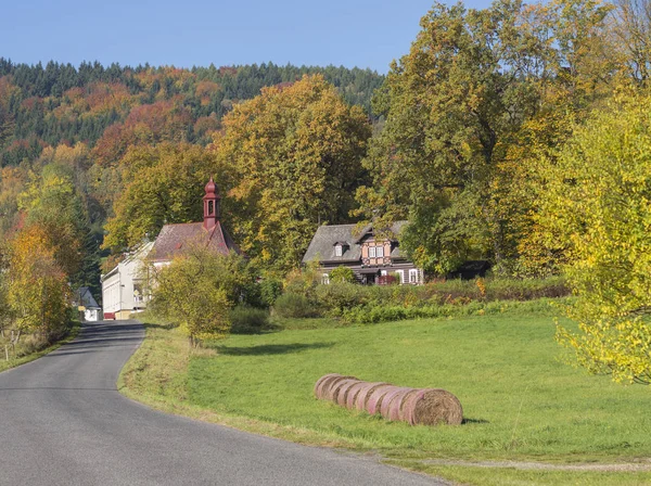 Strada per la cappella del villaggio in autunno paesaggio rurale con paglia — Foto Stock