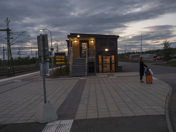 Kiruna, Norrbotten, Suecia, 22 de agosto de 2019: Estación de tren de Kiruna con mujer esperando el tren en la noche de verano. Kiruna es la ciudad más septentrional de Suecia, provincia de Laponia, Skandinavia. . — Foto de Stock