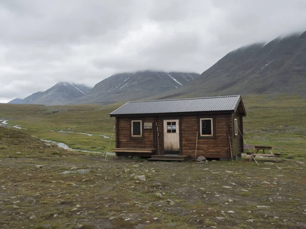 Salka, Norrbotten, Sweden, Agust 26, 2019：View on Salka Stf mountain cabin hut. 翠绿的小山，水坑，阴天的雨天，在昆斯莱登小径上 — 图库照片