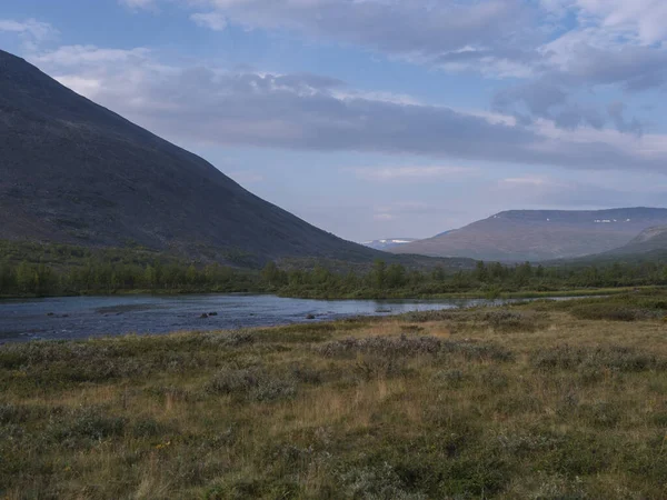美丽的拉普兰野生风景，有蓝色的Tjaktjajakka河，Kaitumjaure，桦树林和山Sanjartjakka 。 瑞典北部夏天在Kungsleden徒步小径。 蓝天背景 — 图库照片