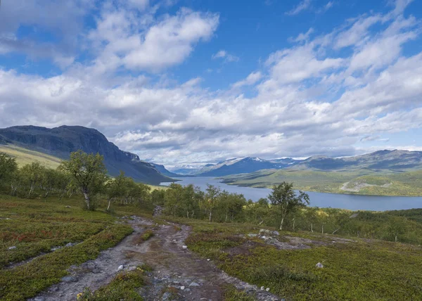 Lappföldi táj gyönyörű folyó Lulealven, hó sapkás hegy, nyírfa és gyalogút Kungsleden túraútvonal közelében Saltoluokta, Észak-Svédország vad természet. Nyári kék ég — Stock Fotó