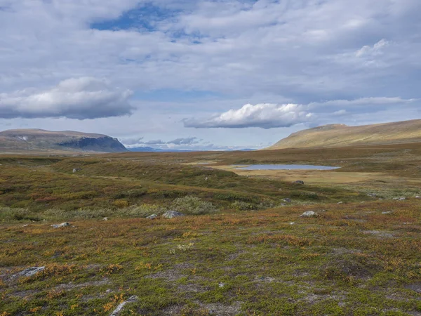 Lapland landschap met blauw meer, besneeuwde berg op Kungsleden wandelpad bij Saltoluokta, Zweden. Wilde natuur met herfstkleurige struiken, berkenbomen en heide. Blauwe lucht witte wolken. — Stockfoto