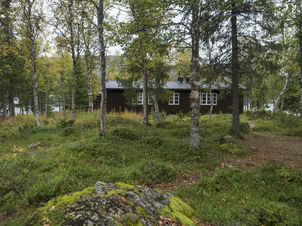 Pohled na horskou chatu Parte Fjallstuga Stf ve Švédsku Laponsko s jezerem Sjabatjakjaure, zelenými kopci a břízou. Kemp na Kungsanské stezce — Stock fotografie