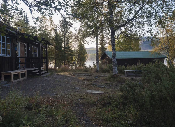 Parte, Norrbotten, Sweden, September 3, 2019: Morning sunrise at Parte Fjallstuga Stf mountain cabin hut with Lake Sjabatjakjaure, green hills and birch trees. 瑞典Lapland at the Kungsleden Trail — 图库照片