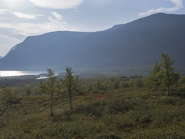 Prachtige wilde Lapland natuurlandschap met Stf Kaitumjaure Berghut, meer, berkenbos en bergen. Noord-Zweden zomer op Kungsleden wandelpad. Blauwe lucht achtergrond — Stockfoto