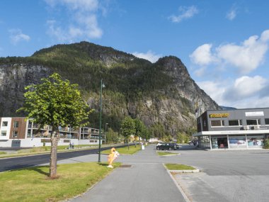 Valldal, Norveç, 7 Eylül 2019: Valldal, Norddal 'da Bunnpris süpermarketi ve macera merkezi olan ana yol. Yüksek uçurumlar, dağlar ve orman, Valldalen vadisi ve yaz masmavi gökyüzü.