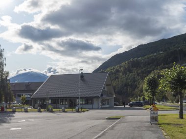 Valldal, Norveç, 7 Eylül 2019: Valldal köyü, Norddal Belediyesi 'nin idari merkezi, More og Romsdal. Yüksek uçurumlar, dağlar ve orman, Valldalen vadisi ve yaz masmavi gökyüzü.