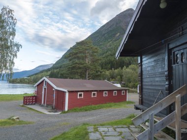 Norveç 'in Kinsarvik kentindeki Hardanger Fjord' un Sorfjorden kolu tarafından Kinsarvik 'te geleneksel ahşap kulübeleriyle klasik Norveç kamp alanı Bravoll manzarası